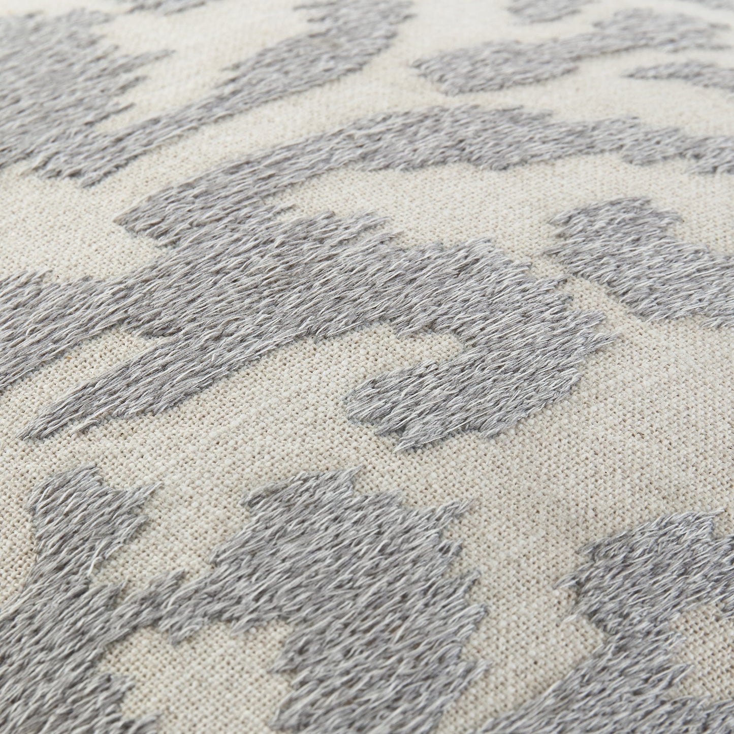 Coussin brodé à la main gris lunaire de la collection Ikat