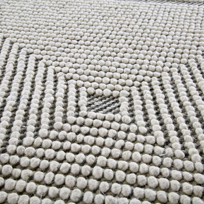 Tapis rond en laine tissé à la main Avanti, motif sel et poivre, à pompons et diamants