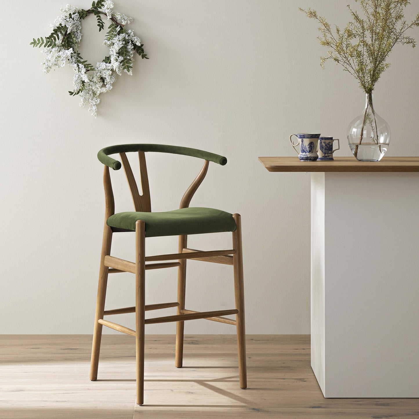 Tabouret de bar rembourré Hansel Wishbone, velours vert mousse et cadre en noyer clair