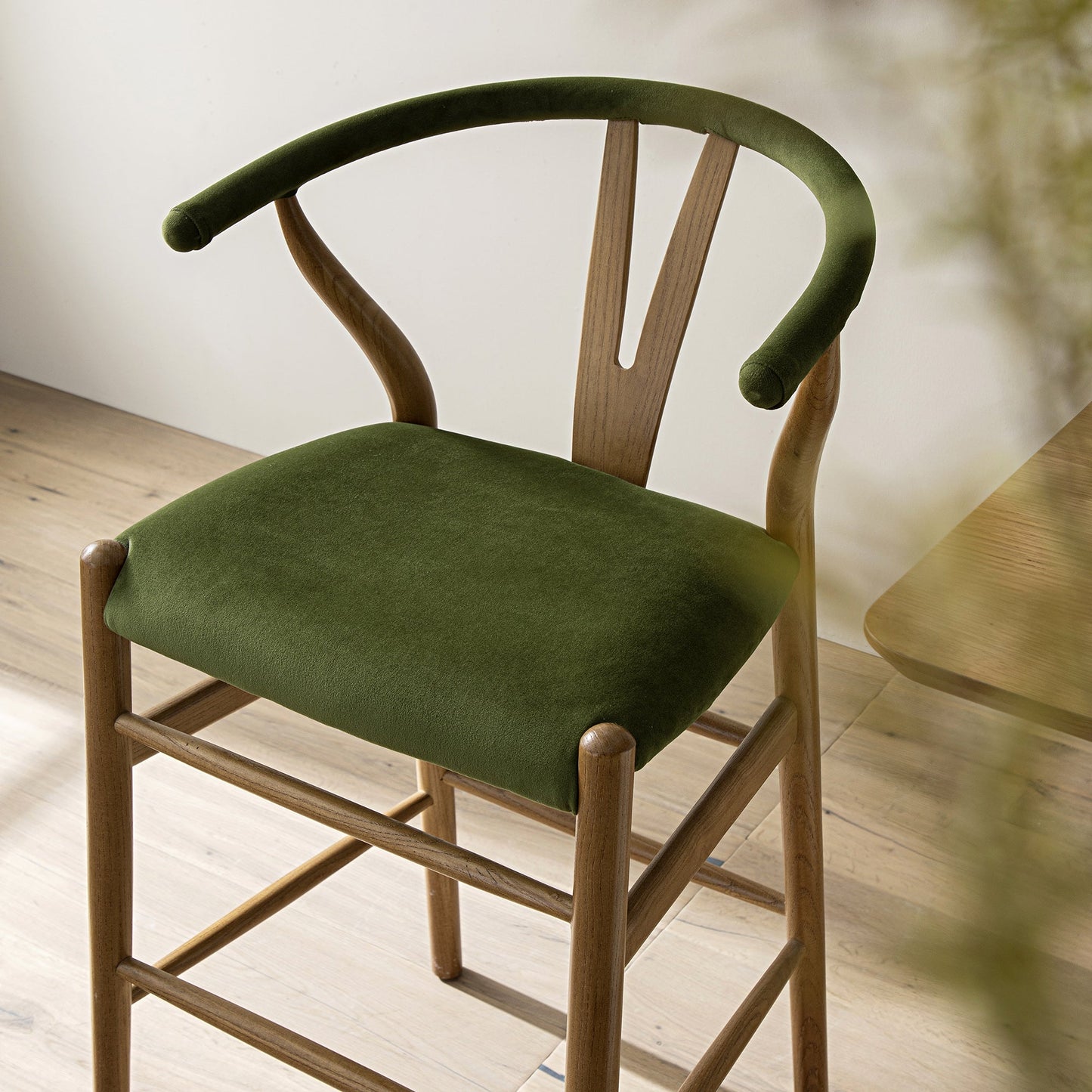Tabouret de bar rembourré Hansel Wishbone, velours vert mousse et cadre en noyer clair