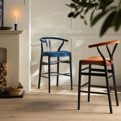 Tabouret de bar rembourré Hansel Wishbone, velours bleu et cadre noir